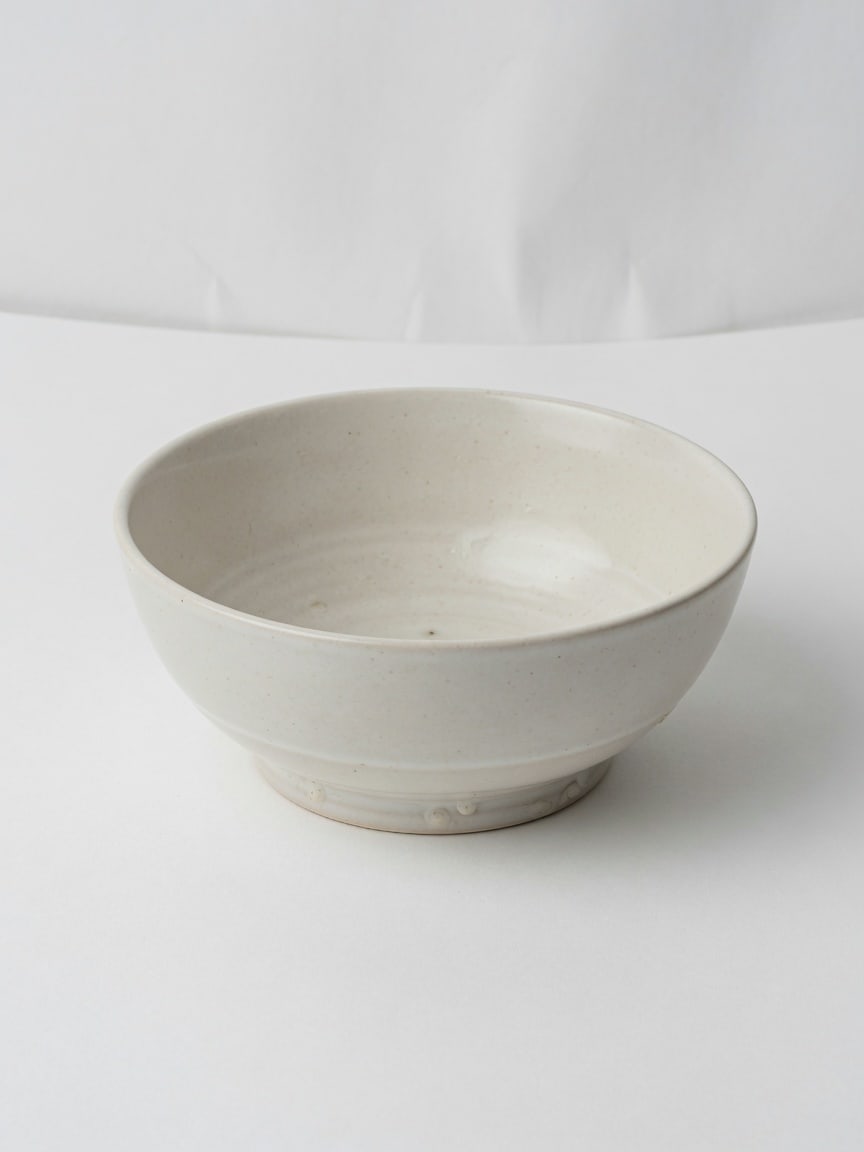 Empty ceramic bowl on a white studio sweep.