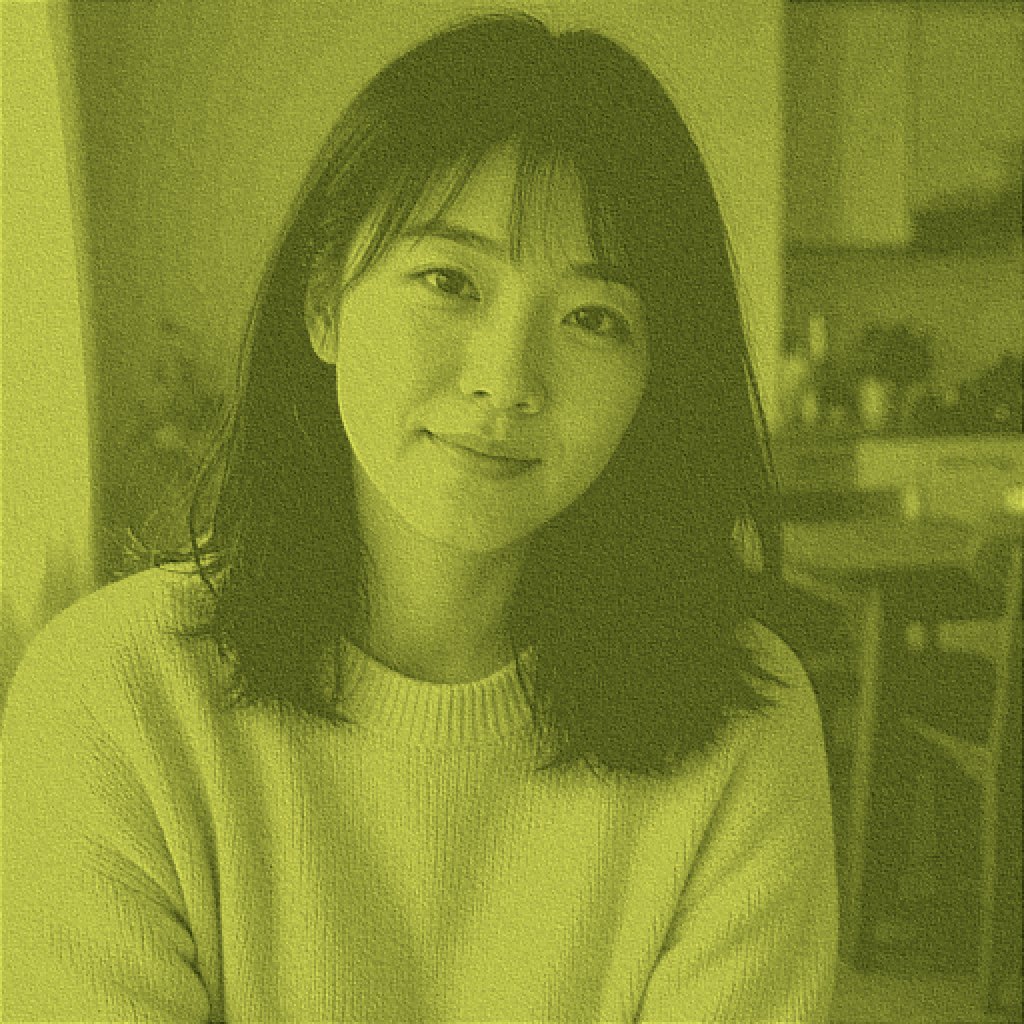Selfie of a woman in a cream sweater under a green matcha wash before a remove matcha filter pass.